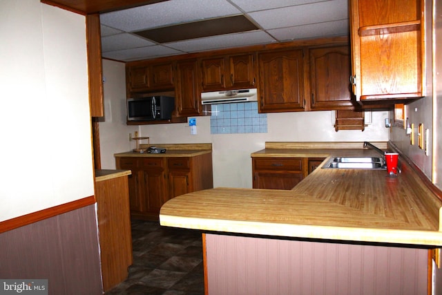 kitchen with sink, a paneled ceiling, and kitchen peninsula