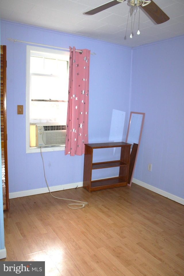 spare room with wood-type flooring, ceiling fan, and cooling unit