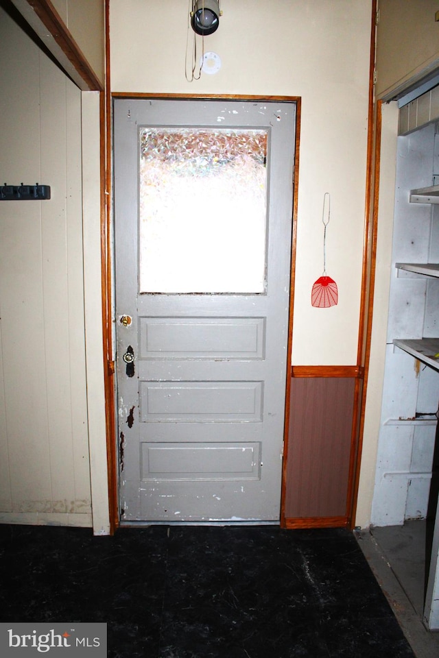 doorway to outside featuring wood walls