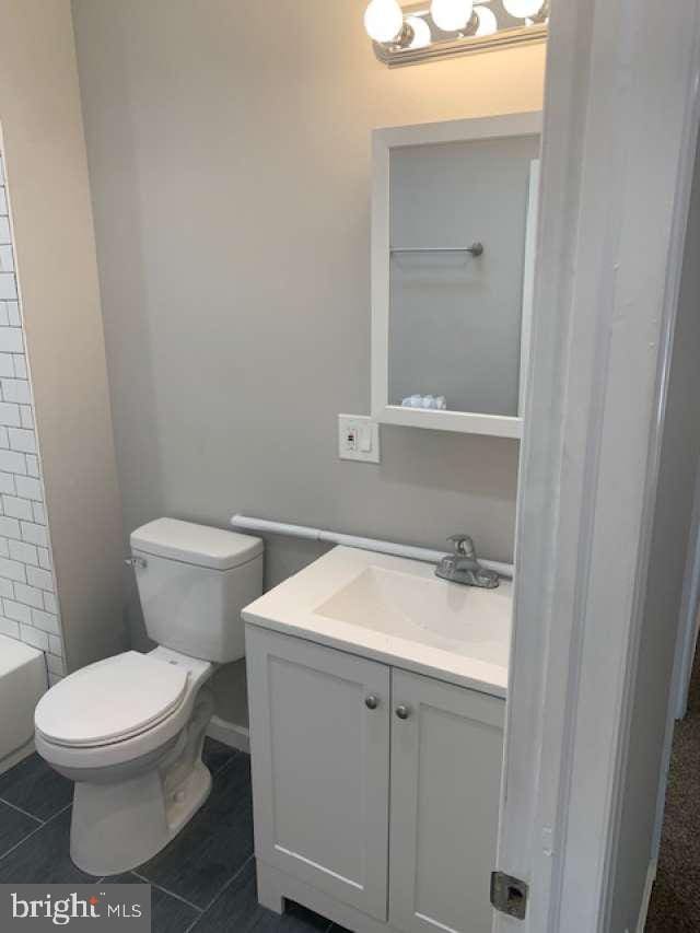 bathroom with vanity, toilet, and tile patterned floors