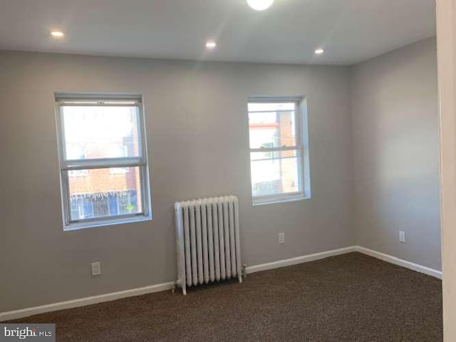 carpeted spare room with radiator heating unit