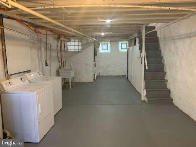 basement featuring washer and clothes dryer and sink