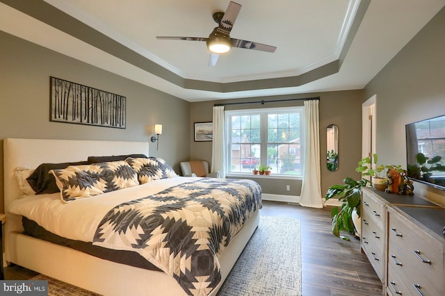 bedroom featuring ornamental molding, a tray ceiling, ceiling fan, and dark hardwood / wood-style flooring