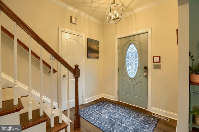 entryway with ornamental molding, a notable chandelier, and dark wood-type flooring