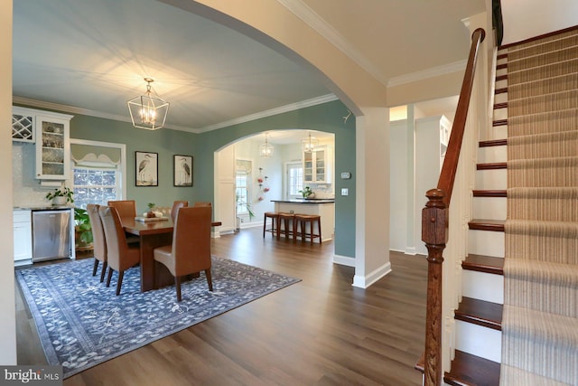 dining space with an inviting chandelier, crown molding, and dark hardwood / wood-style flooring