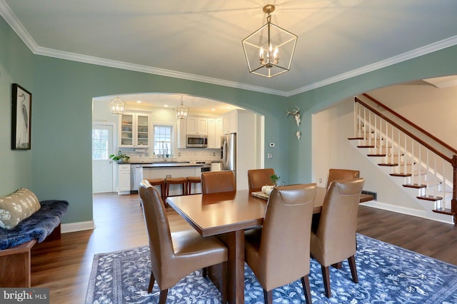 dining room featuring an inviting chandelier, dark hardwood / wood-style floors, and ornamental molding