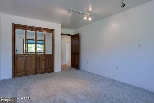 interior space featuring light carpet and rail lighting