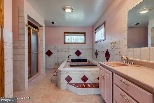 bathroom with tile walls, vanity, shower with separate bathtub, and tile patterned floors