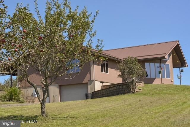 view of side of home featuring a garage and a yard