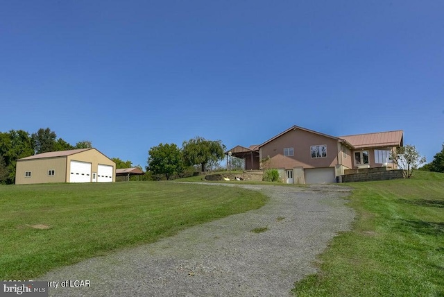 view of front of home featuring a front lawn, an outdoor structure, and a garage