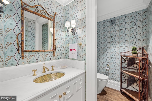 bathroom with wood-type flooring, ornamental molding, toilet, and vanity