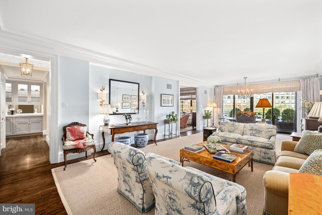 living room with a notable chandelier, dark hardwood / wood-style floors, and crown molding