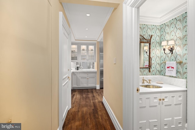 hallway with dark hardwood / wood-style floors, ornamental molding, and sink