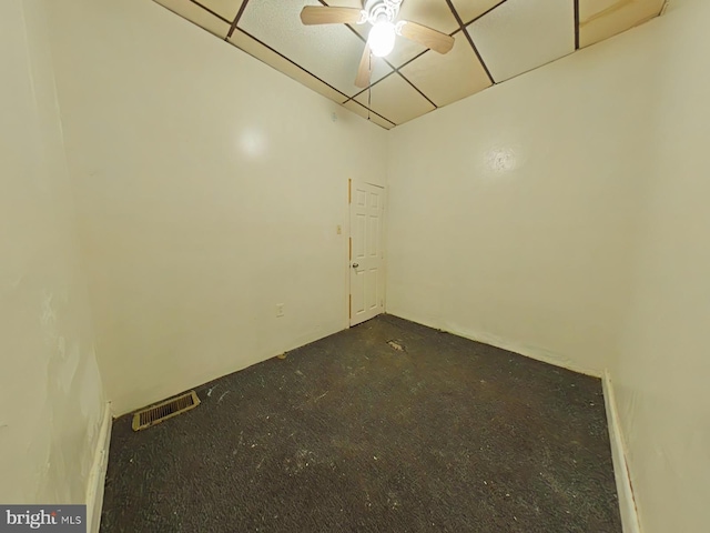 empty room featuring dark carpet and ceiling fan