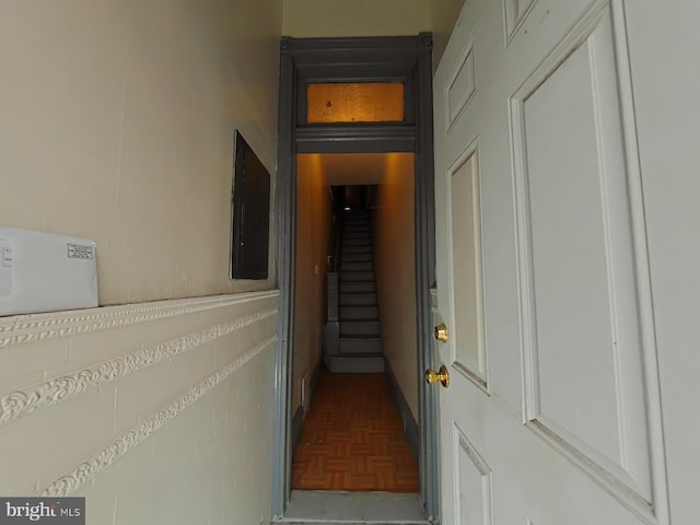 corridor with parquet flooring and electric panel