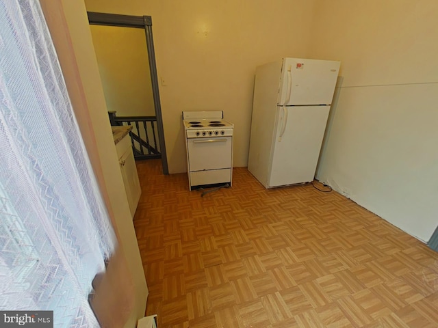 interior space featuring white cabinetry, white appliances, and light parquet floors