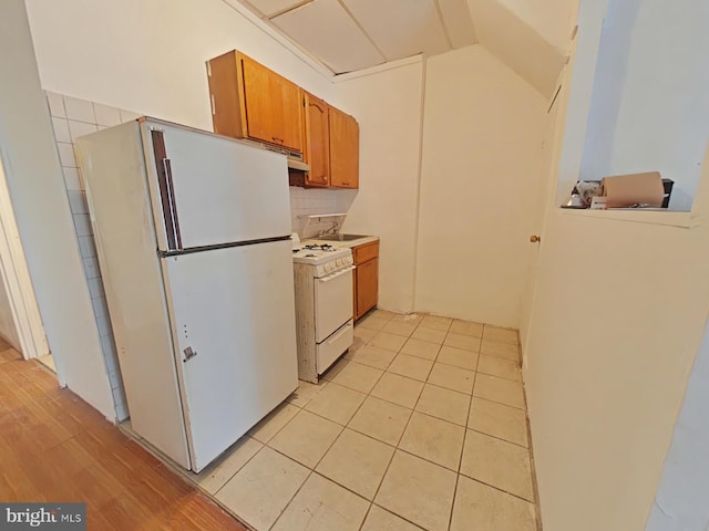 kitchen with white appliances, sink, and light tile patterned floors