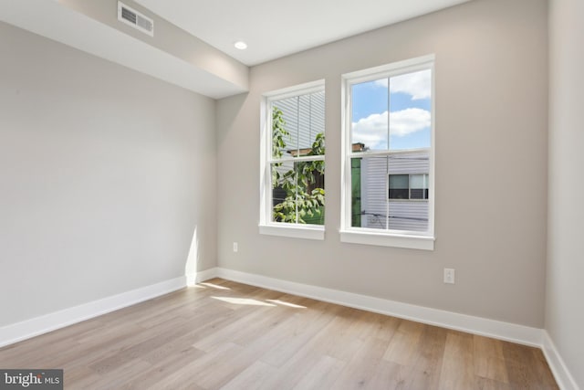 empty room featuring a healthy amount of sunlight and light hardwood / wood-style floors