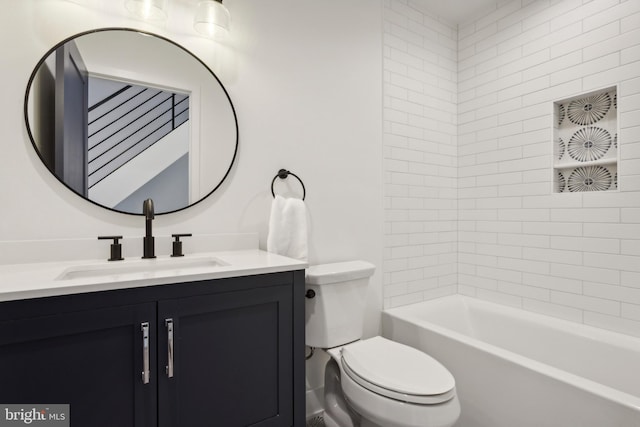 full bathroom featuring tiled shower / bath, vanity, and toilet