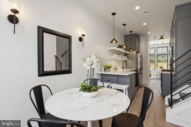 dining room with light hardwood / wood-style flooring and sink