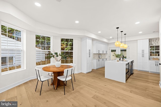 dining space with light hardwood / wood-style flooring and sink