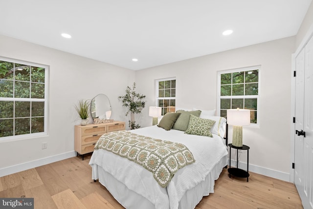 bedroom featuring multiple windows and light hardwood / wood-style flooring