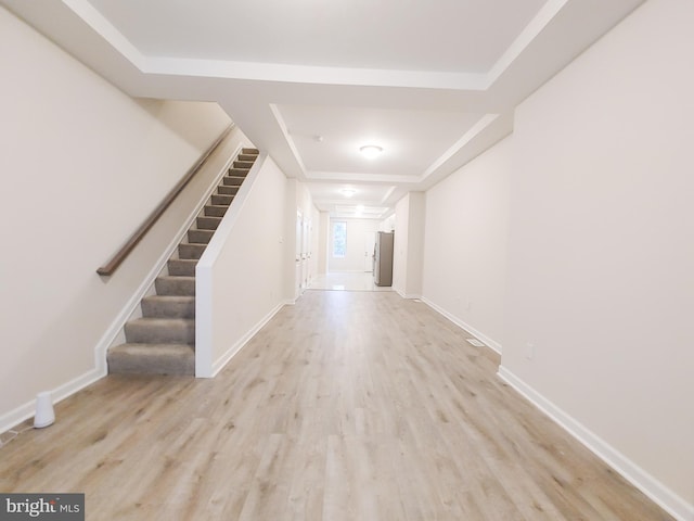 entrance foyer featuring light hardwood / wood-style flooring and a raised ceiling