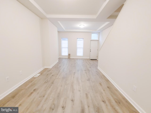 interior space with light hardwood / wood-style flooring and a raised ceiling