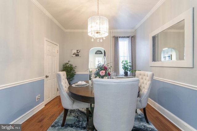 dining area with ornamental molding, a chandelier, and dark hardwood / wood-style flooring