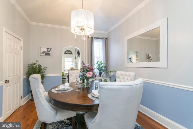 dining room featuring hardwood / wood-style flooring, crown molding, and a chandelier