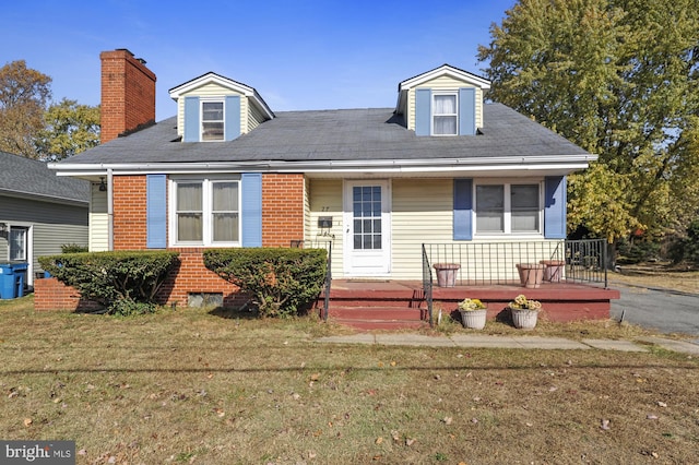 cape cod-style house with a front lawn and a deck