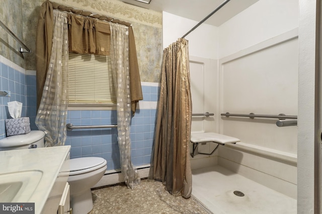 bathroom featuring vanity, curtained shower, tile walls, and toilet