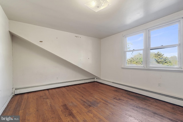 empty room with baseboard heating and dark hardwood / wood-style floors