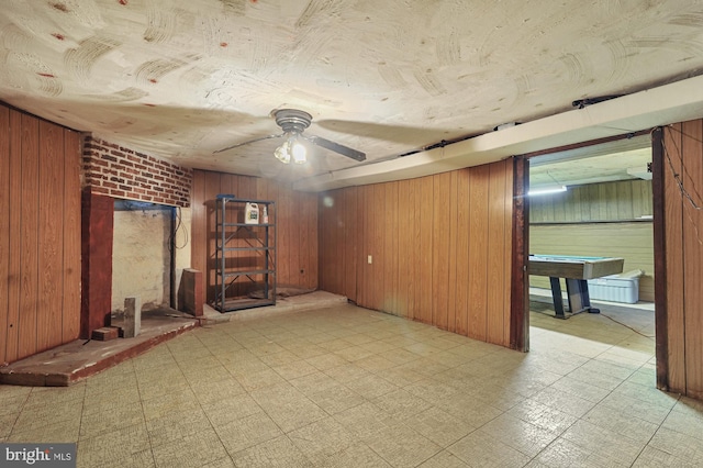 empty room featuring wood walls, ceiling fan, and billiards