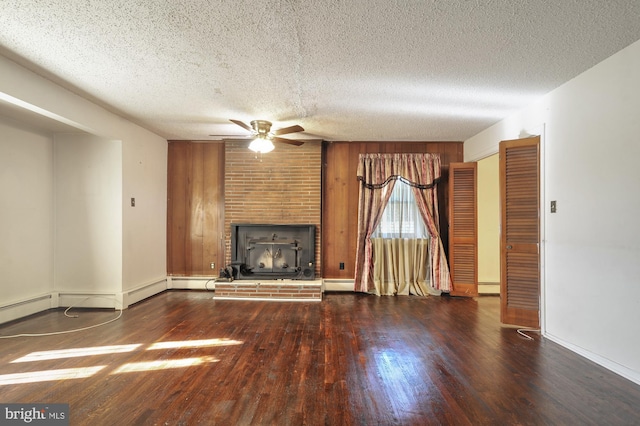 unfurnished living room with a baseboard radiator, wooden walls, a textured ceiling, and dark hardwood / wood-style flooring