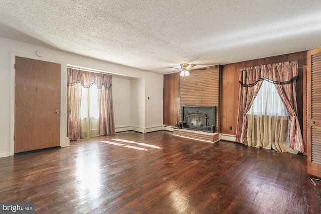 unfurnished living room with a textured ceiling, a healthy amount of sunlight, dark hardwood / wood-style floors, and ceiling fan