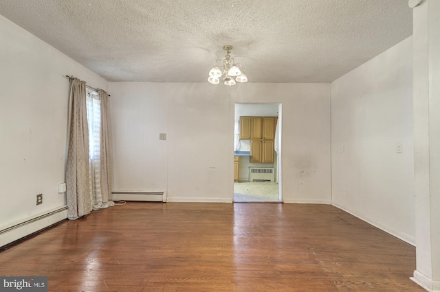 unfurnished room featuring a textured ceiling, radiator heating unit, dark hardwood / wood-style floors, and a chandelier