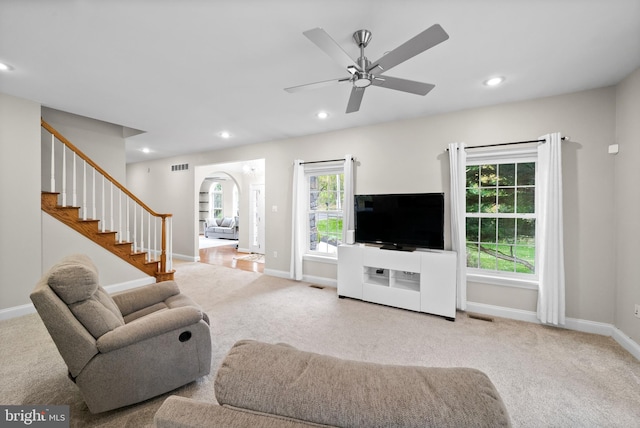 carpeted living room featuring ceiling fan