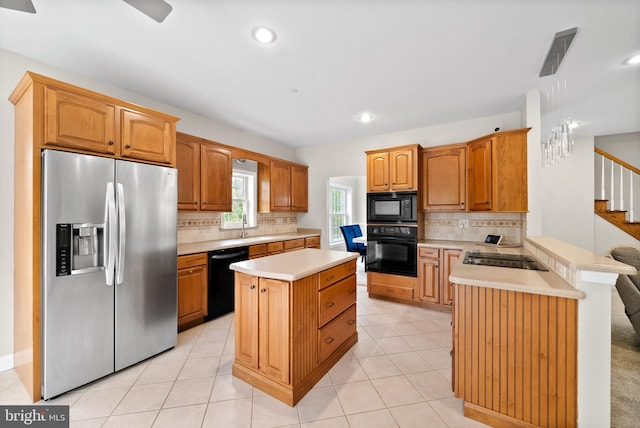 kitchen featuring tasteful backsplash, a kitchen island, black appliances, light tile patterned floors, and ceiling fan