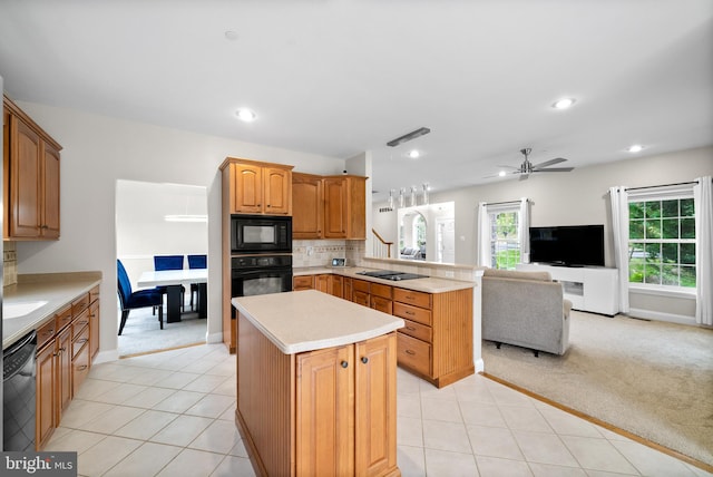 kitchen with kitchen peninsula, light tile patterned floors, black appliances, a center island, and ceiling fan