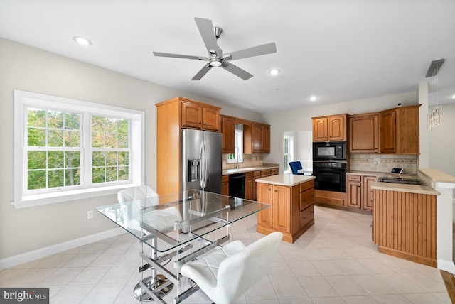 kitchen with a center island, sink, decorative backsplash, black appliances, and ceiling fan