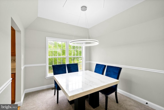 dining space featuring a notable chandelier, vaulted ceiling, and carpet floors