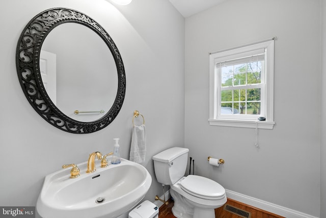 bathroom featuring wood-type flooring, sink, and toilet