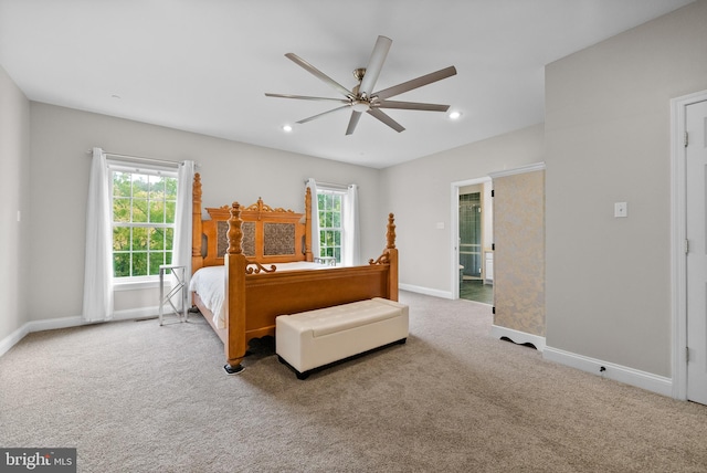 bedroom featuring multiple windows, light carpet, and ceiling fan