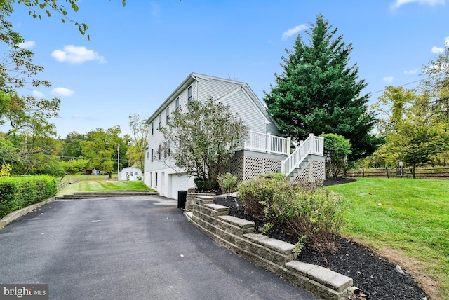 view of property exterior featuring a yard and a garage