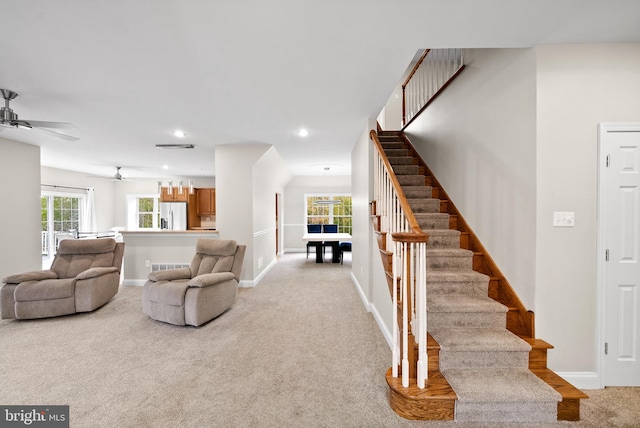 carpeted living room with ceiling fan