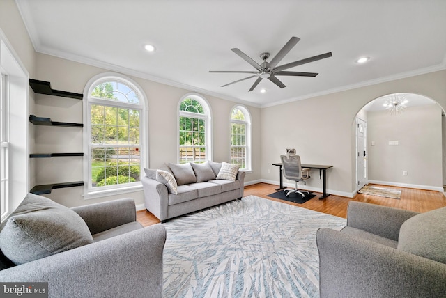 living room with light hardwood / wood-style floors, ornamental molding, and ceiling fan