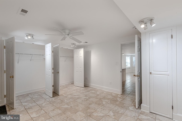 unfurnished bedroom with two closets and ceiling fan