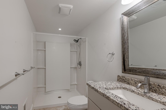 bathroom with a shower, vanity, and toilet