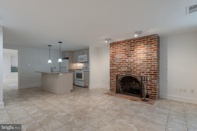 unfurnished living room with sink and a brick fireplace